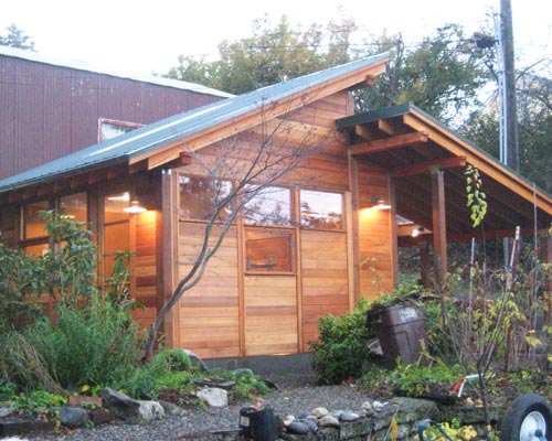 Careful placement of windows and doors, and an extra-tall entrance door brings lots of light into this cedar-clad shop and Seattle garage plans.  The framing elements were designed to be seen instead of hidden, garage plans Seattle