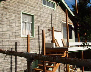 Before:  funky siding and a partly finished deck, ready for a seattle porch rebuild