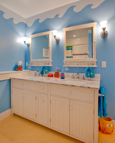 A seaside motif for the kids bathroom.  Pottery Barn cabinets with marble countertops and lots of color make this a great bathroom to share