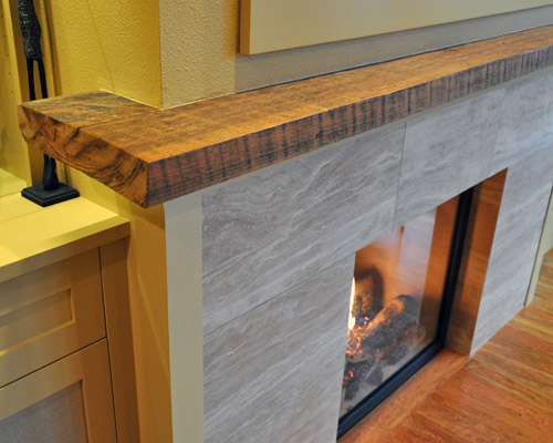 The mantle was the only thing saved from the original fireplace--a slab of wood that had been salvaged from a local historic building many years ago. The ends required cuts, so our carpenters artistically reproduced the colors of the rest of the slab on the cut ends