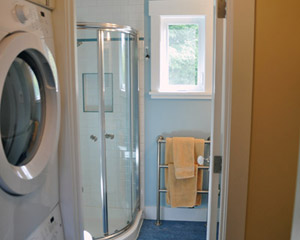 Directly adjacent to the bedroom are the laundry and bath areas.  A stacking washer/dryer fits neatly into the alcove, with a closet on the opposite side and a pocket door to close it off for noise