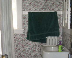Before: Icky wallpaper, bulky radiator and a toilet nearly blocking the entrance to the kids' bath