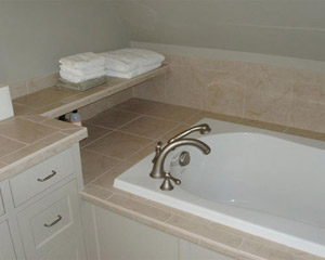 The master bath features a soaking tub with a tiled shelf for towels