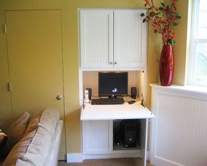 Custom built in place, the cabinet doubles as a computer station.  The door to the left opens up to a mechanical closet, with furnace and hot water heater.