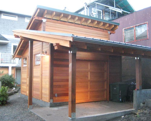 From the opposite side, this new seattle garage remodel has a roll-up door and a carport.  There's also a spot in the corner for recycling and trash containers, custom garage builders Seattle