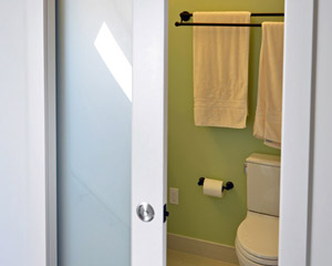 A pocket door with frosted glass is the entry, making it possible to have natural light in the stairwell even if the door is closed