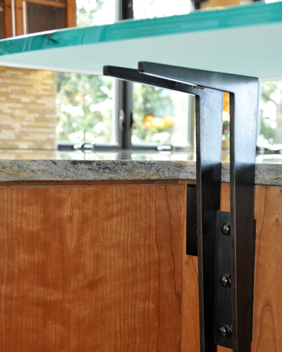 The bar counter supports are custom made from blackened steel.  Three of them hold up the curved 3/4 inch etched glass counter.  The same steel is used in other locations through the home