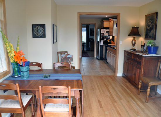 The new wood flooring in the dining room is installed at the same level as the kitchen tile, with a new cased opening between the rooms.  Lots of windows--including ones removed from the new door opening and reinstalled--make the dining room light and bright