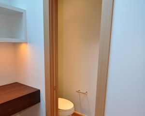 The powder room is conveniently tucked away with a laminated glass pocket door
