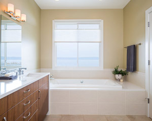 It also features a soaking tub with a view of the water.  Here the counter also waterfalls down from the vanity to the tub deck - peaceful and relaxing