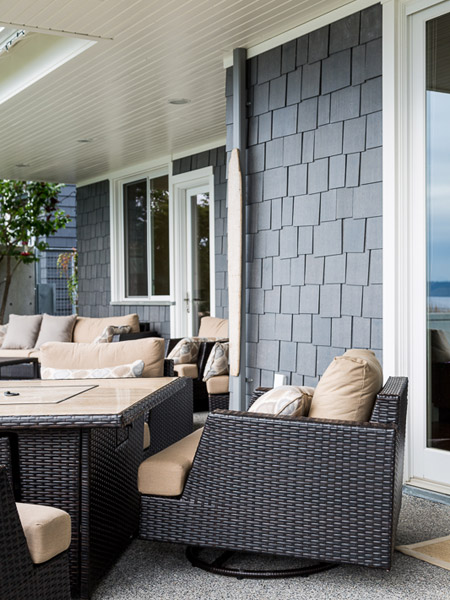The covered patio on the water side of the home provides plenty of sheltered seating and an unobstructed view