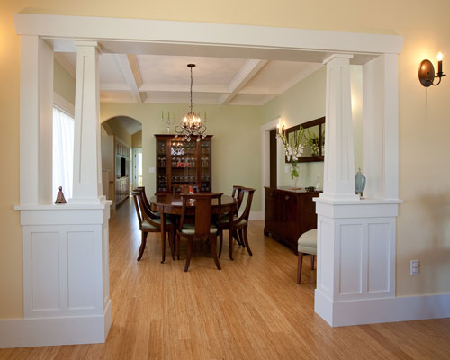 The formal dining room has the same tapered Craftsman columns at its entry, and is defined by hand-crafted box beam at the ceiling.   An arched doorway provides a peek into the kitchen