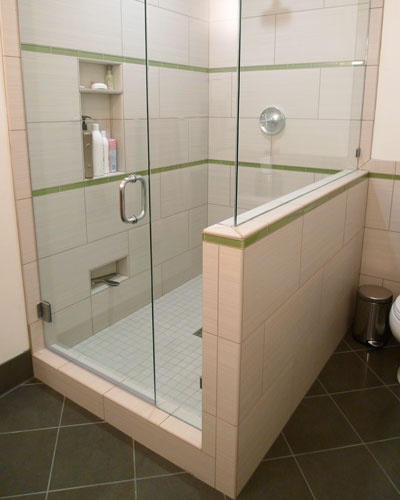 With a commanding spot in the bathroom and glass half walls to let the light in, the shower is both spacious and beautiful.  Niches on the wall provide space for shampoo and the one at the very bottom holds the glass squeegee, and is a convenient leg up while shaving