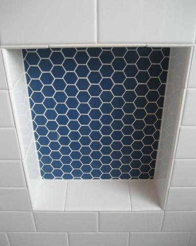 The niche is a deep blue hex tile.  The balance is simple subway tile. Seattle custom hexagon tile