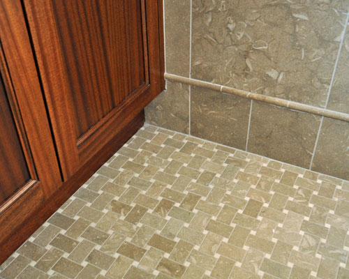 The cabinetry is set off visually from the subtle and beautiful tile work.  The tile is sea grass limestone, cut in a field pattern for the walls and a basket weave tile pattern for the floors