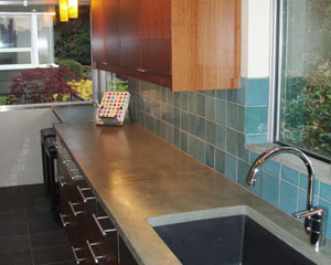 It's a whole new era for this 50s rambler kitchen.  Not a single wall moved, but this transformation is total.  Modern cabinets, a green countertop from Squak Mountain Stone, and cool recycled glass tiles bring this kitchen remodel into the new century. custom tile backsplash